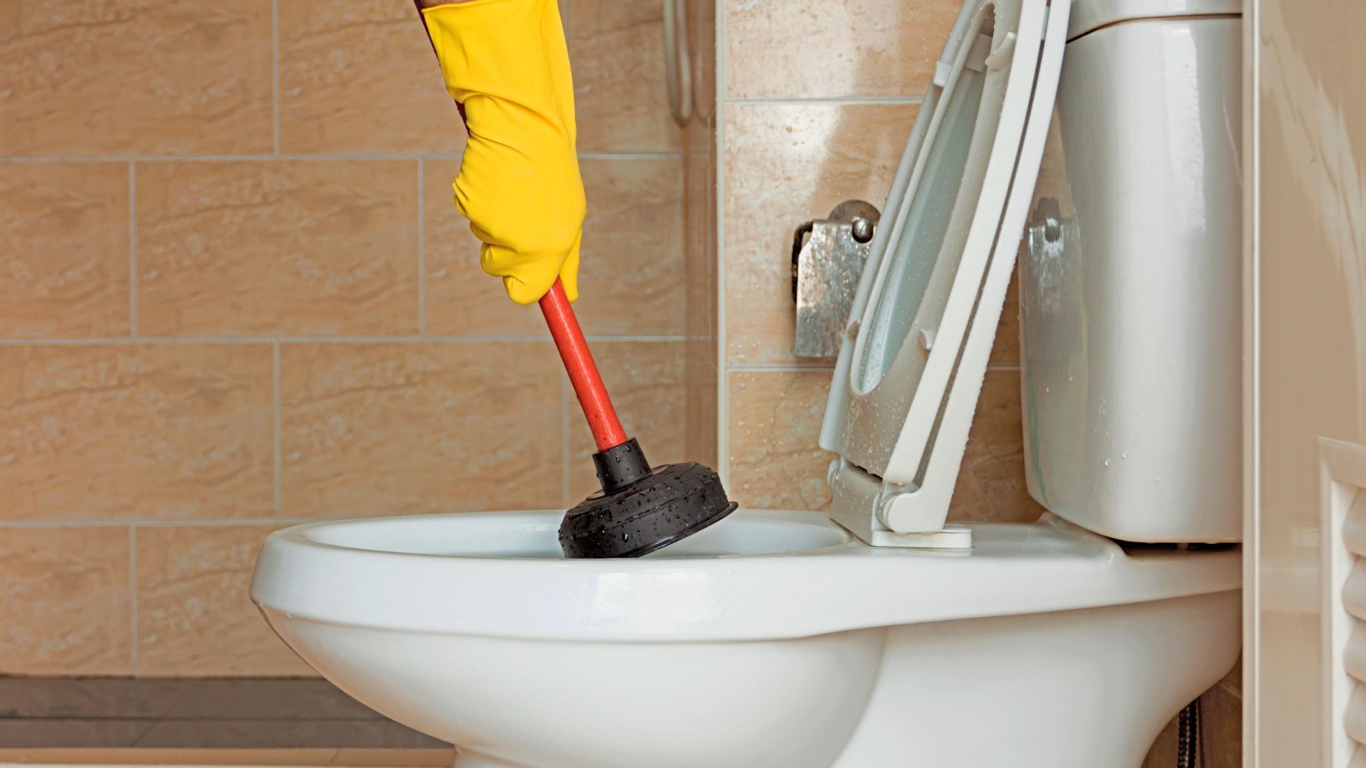 Plumber working on residential faucet and toilet repair